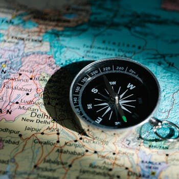 A compass resting on a map of China and India signifies exploration and adventure.